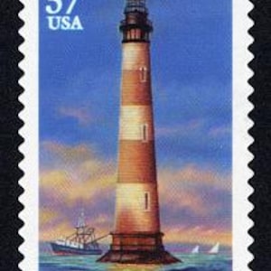 Puede incluir: Un faro rojo y blanco a rayas con un techo negro y una luz en la parte superior. El faro está en el agua con un barco en primer plano y un velero en el fondo. El texto "MORRIS ISLAND, SOUTH CAROLINA" está en la parte inferior de la imagen.