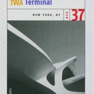 May include: A black and white photograph of the TWA Terminal in New York, NY. The terminal is a modern architectural design with a curved roof. The image is a stamp with the text "TWA Terminal" and "New York, NY" and the number "37" in red.