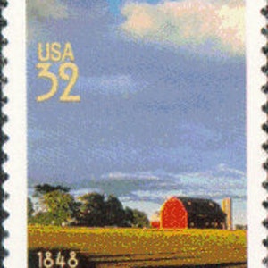 Op de afbeelding: Een vintage Amerikaanse postzegel met een rode schuur in een veld met een blauwe lucht en witte wolken. De postzegel toont "USA 32" en "1848 WISCONSIN".