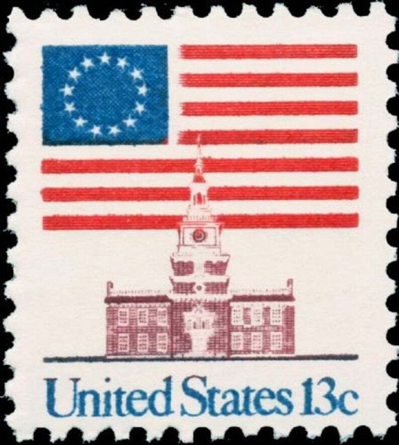 Puede incluir: Un sello postal estadounidense vintage que presenta una bandera estadounidense roja, blanca y azul con 13 estrellas, un edificio con una torre de reloj y el texto "United States 13c".