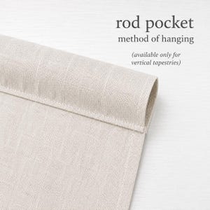 a close-up view of a beige fabric, possibly a piece of clothing or a textile, with a folded or rolled end. The text above the image reads "rod pocket method of hanging" and below it, "(available only for vertical tapestries)"