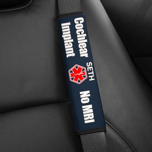 May include: Blue car seatbelt cover with white text that reads "Cochlear Implant Seth No MRI" and a red medical symbol.