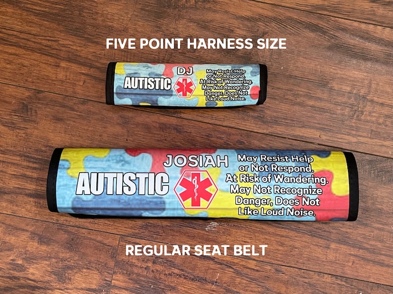 K&ouml;nnte beinhalten: Zwei bunte Sicherheitsgurt-Abdeckungen mit dem Wort "AUTISTIC" darauf gedruckt. Die Abdeckungen enthalten auch ein rotes Stern-des-Lebens-Symbol und einen Text, der lautet "May Resist Help or Not Respond. At Risk of Wandering. May Not Recognize Danger, Does Not Like Loud Noise." Eine Abdeckung ist mit "DJ" und die andere mit "JOSIAH" beschriftet. Die obere Abdeckung ist mit "FIVE POINT HARNESS SIZE" und die untere mit "REGULAR SEAT BELT" beschriftet.