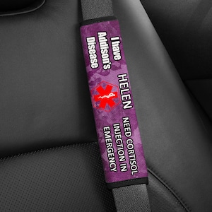 May include: Purple and black car seatbelt safety strap with the text "I have Addison's Disease HELEN NEED CORTISOL INJECTION IN EMERGENCY" and a red medical symbol.