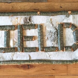 custom personalized sign made with twigs backed with birch bark.