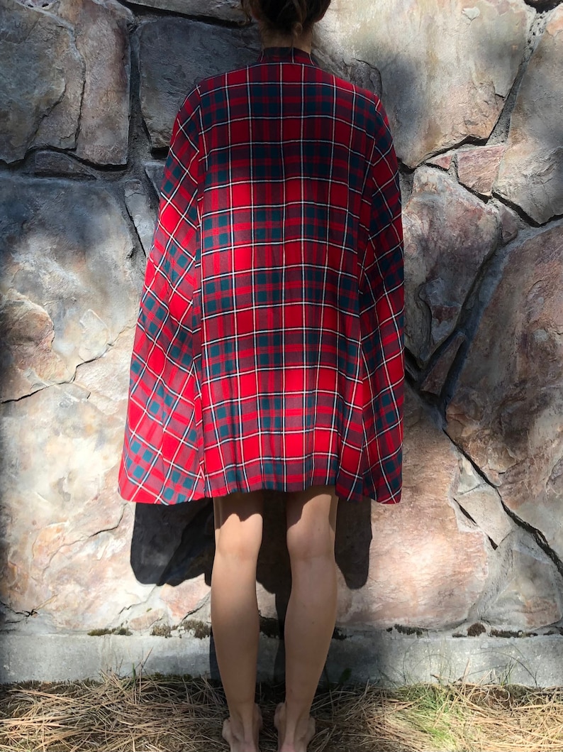 May include: A red, green, and white plaid cape with a long, flowing design.
