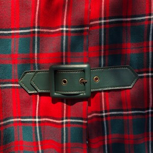 May include: A red and green plaid skirt with a dark green leather belt and a silver buckle.