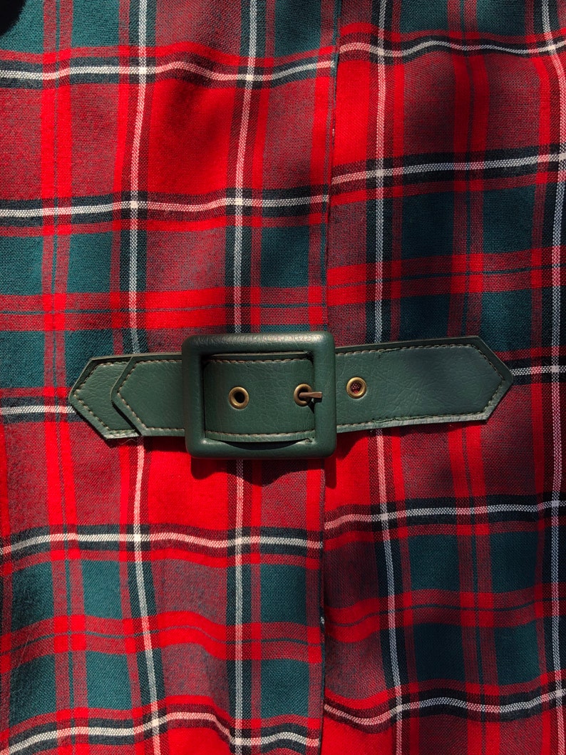 May include: A red and green plaid skirt with a dark green leather belt and a silver buckle.