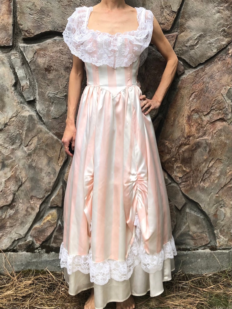 May include: A vintage pink and white striped satin dress with a lace bodice and trim. The dress has a fitted bodice and a full skirt.