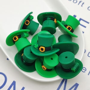 May include: A collection of green and gold leprechaun hats with a shamrock design. The hats are made of a soft, pliable material and are perfect for adding a touch of Irish charm to any craft project.