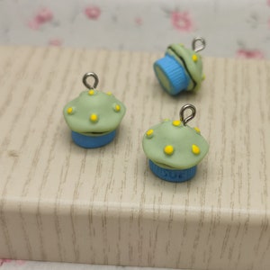 May include: Three small green and blue cupcake charms with yellow sprinkles and silver jump rings.