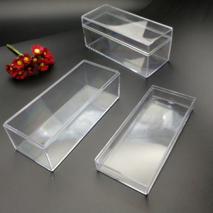 Peut inclure: Trois boîtes rectangulaires en plastique transparent de tailles différentes. Les boîtes sont vides et ont une finition lisse et brillante.