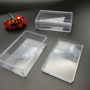 May include: Three clear plastic boxes of different sizes. The boxes are empty and have a rectangular shape.