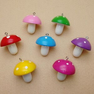 May include: Seven colourful wooden mushroom charms with white polka dots. Each charm has a silver loop for hanging.