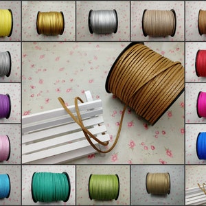 Op de afbeelding: Assortiment van 12 spoelen met kunstleerkoord in verschillende kleuren, waaronder geel, zilver, paars, roze, lichtblauw, teal, groen, bruin, beige, rood, fuchsia en blauw. De koorden zijn om spoelen gewikkeld en tentoongesteld op een witte houten bank.
