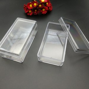 Puede incluir: Dos cajas rectangulares de plástico transparente con tapas. Las cajas están vacías y tienen un ligero brillo.