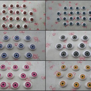 Puede incluir: Surtido de 20 ojos de muñeca de plástico en varios colores, incluyendo marrón, azul, gris, rosa y amarillo. Los ojos son todos de forma ovalada y tienen una esclerótica blanca con un iris de color.