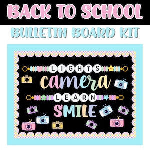 May include: A bulletin board kit featuring a black background with a scalloped checkered border. The text reads LIGHTS, camera, LEARN, and SMILE in colorful fonts. Decorative elements include pastel-colored cameras, beads, stars, and flowers.