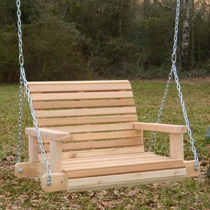 Puede incluir: Un columpio de madera con respaldo y asiento de listones, y dos reposabrazos. El columpio est&aacute; colgado de dos cadenas unidas a un marco de metal.