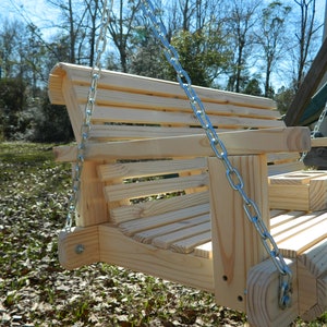 May include: A wooden swing with a slatted back and seat, hanging from two silver chains. The swing is made of unfinished wood and has a natural wood color.