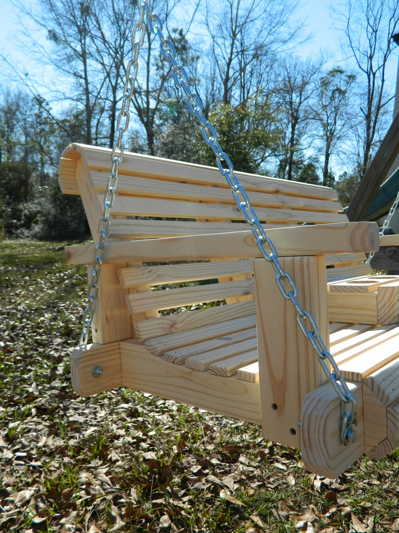 May include: A wooden swing with a slatted back and seat, hanging from two silver chains. The swing is made of unfinished wood and has a natural wood color.