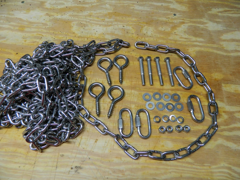 May include: A set of silver-toned hardware for hanging a swing or other outdoor equipment. The set includes a chain, two eye hooks, four screws, eight washers, four nuts, and two quick links.