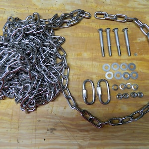 May include: A set of silver hardware for hanging a swing or other object. The set includes a chain, two hooks, four bolts, eight washers, and eight nuts.