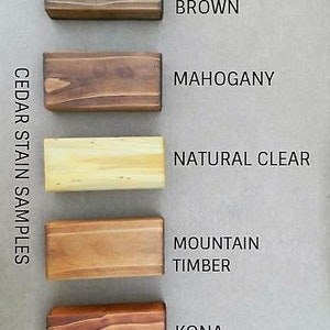K&ouml;nnte beinhalten: Zedernholz-Beizenproben in f&uuml;nf verschiedenen Farben: Canyon Brown, Mahagoni, Naturklar, Berg-Holz und Kona.