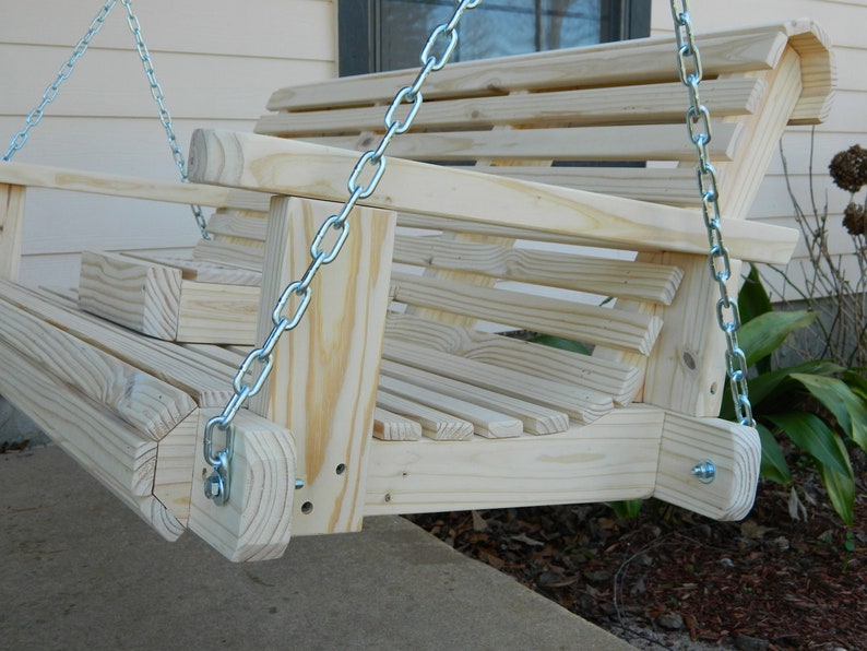 May include: A wooden swing with a slatted back and seat, hanging from two silver chains. The swing is made of unfinished wood and has a natural wood color.