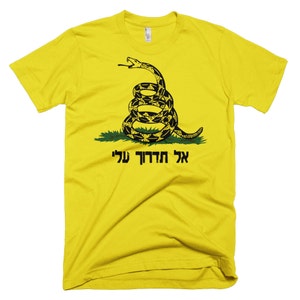 May include: A yellow t-shirt with a black and green image of a coiled snake with the text "Don't Tread On Me" in Hebrew.