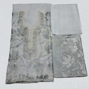 Op de afbeelding: Een grijze geborduurde jurk met een zilveren bloemenpatroon. De jurk wordt geleverd met een bijpassende dupatta.