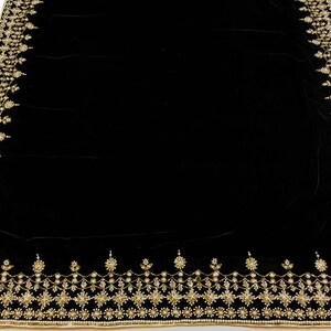 Puede incluir: Tela de terciopelo negro con un borde bordado en oro. El borde presenta un patr&oacute;n repetitivo de dise&ntilde;os florales y geom&eacute;tricos.