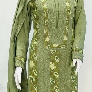 May include: An olive green long-sleeved tunic and matching scarf set featuring intricate tonal embroidery, decorative leaf and paisley appliqu&eacute; patterns, and subtle sequin embellishments along the neckline, cuffs, and front panel.