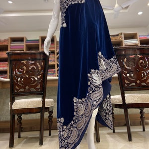 May include: A navy blue velvet shawl with silver embroidery. The shawl is draped over a mannequin and has a paisley design.