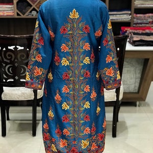 May include: A long, blue silk robe with intricate floral embroidery in shades of orange, red, and yellow. The robe has a high neckline and long sleeves.