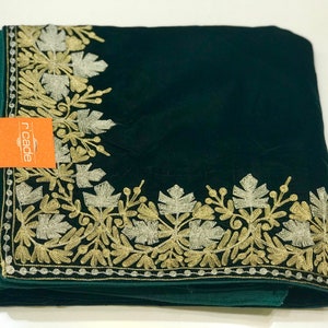 May include: A dark green velvet shawl with a gold and silver embroidered floral border. The shawl is folded and the brand name "ricade" is visible on a small orange tag.