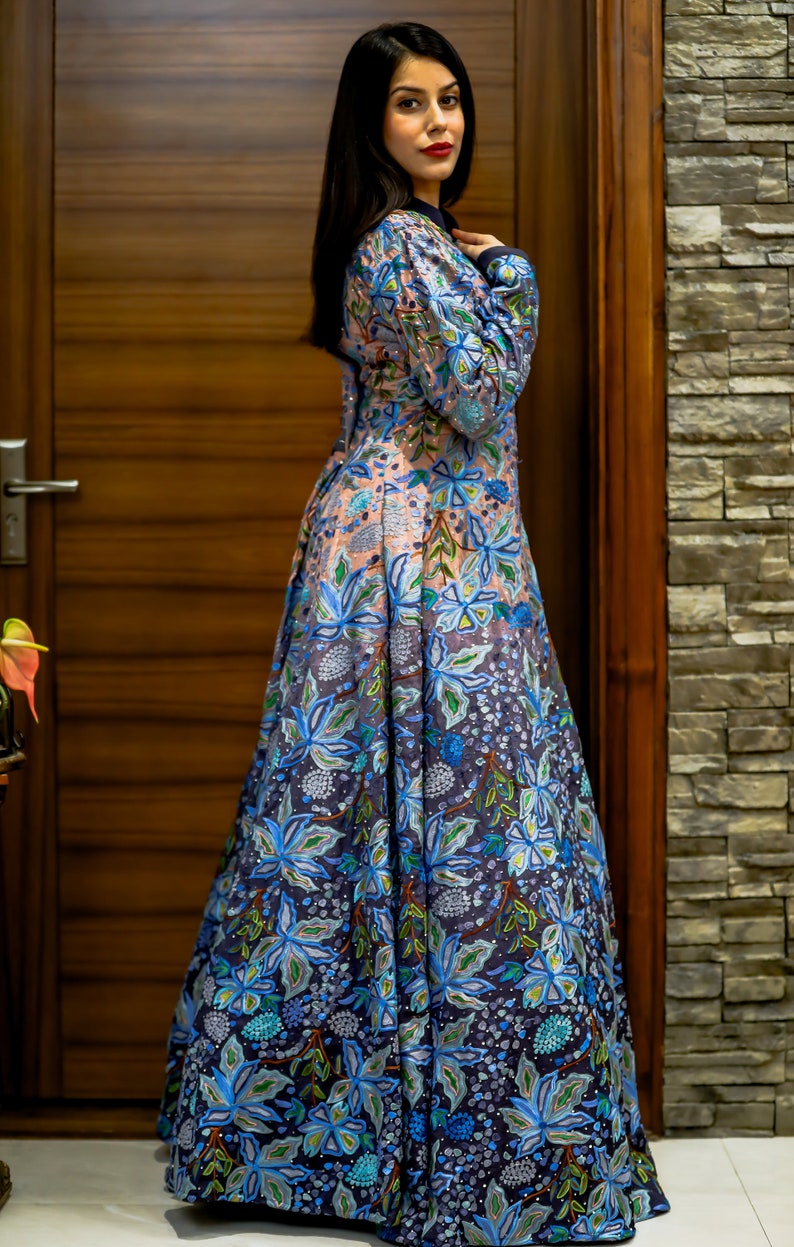 May include: A long, flowing dress with a floral print in shades of blue, green, and pink. The dress has a fitted bodice and a full skirt.