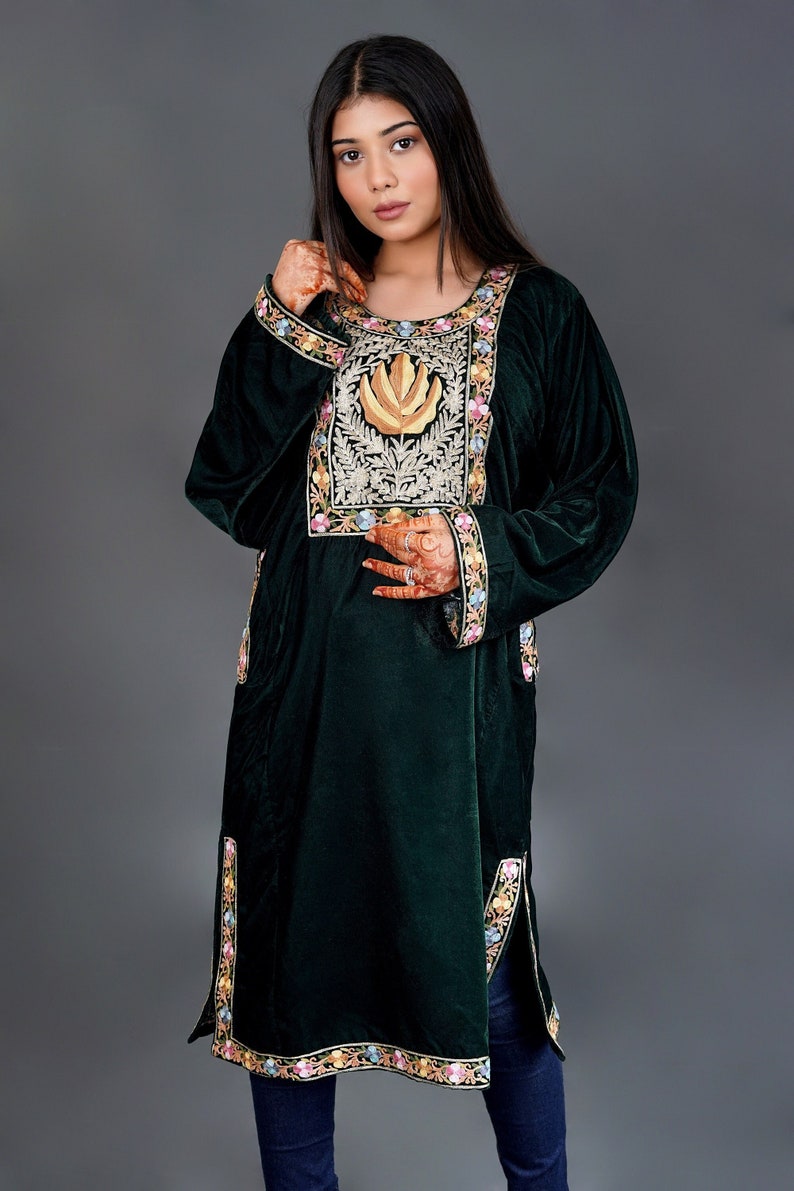 May include: A dark green velvet tunic featuring a prominent rectangular chest panel with gold leaf embroidery and intricate floral needlework. The garment includes long sleeves with matching floral borders at the cuffs and hemline, plus side slits.