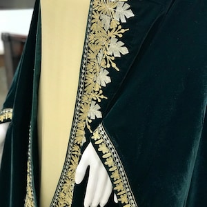 May include: A dark green velvet shawl with gold and silver embroidery. The embroidery features a floral design with leaves and vines.