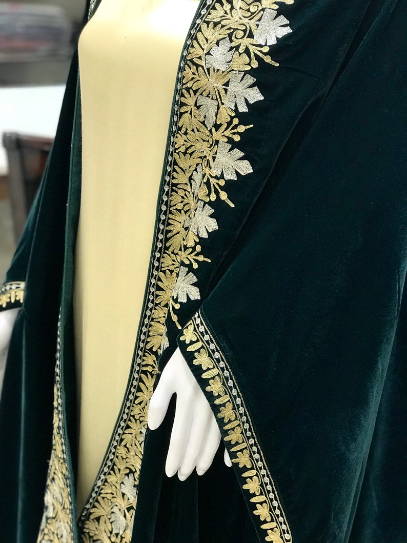 May include: A dark green velvet shawl with gold and silver embroidery. The embroidery features a floral design with leaves and vines.