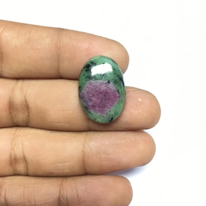 May include: Oval-shaped green gemstone with a pink and white starburst pattern.