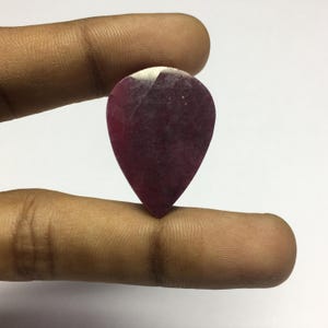 Op de afbeelding: Een traanvormige, diep roze edelsteen met een witte rand.