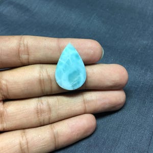 May include: A teardrop-shaped cabochon of blue and green gemstone with a marbled pattern.