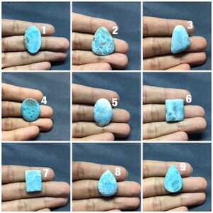 May include: Nine different cabochon gemstones, each with a unique shape and pattern. The gemstones are all a light blue color with white and gray swirls. The gemstones are numbered 1 through 9.