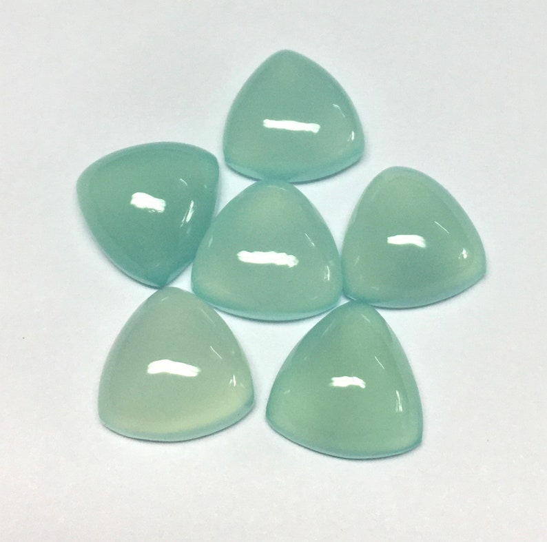 Puede incluir: Seis piedras preciosas triangulares de cabuj&oacute;n azul claro. Las piedras preciosas son lisas y pulidas.