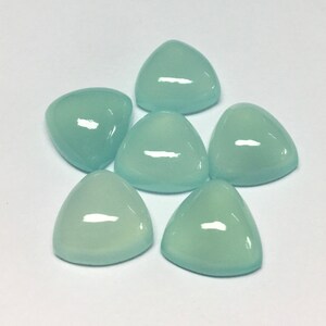 Puede incluir: Seis piedras preciosas triangulares de cabuj&oacute;n azul claro. Las piedras preciosas son lisas y pulidas.