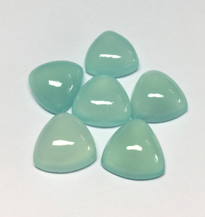 Puede incluir: Seis piedras preciosas triangulares de cabuj&oacute;n azul claro. Las piedras preciosas son lisas y pulidas.