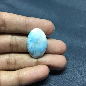 May include: Oval shaped blue and white gemstone with a cloudy pattern.