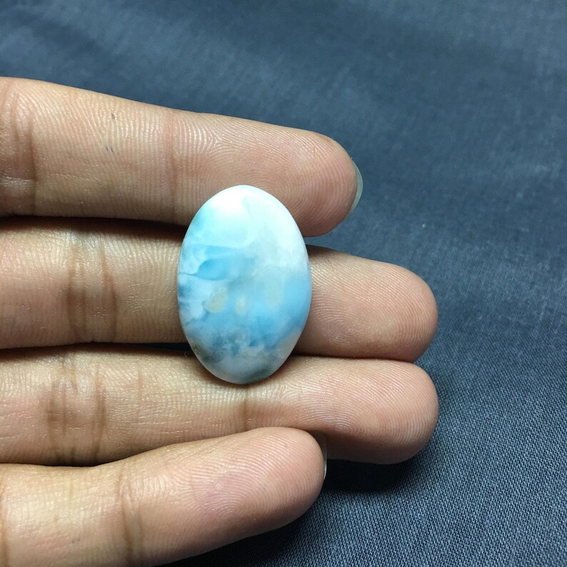 May include: Oval shaped blue and white gemstone with a cloudy pattern.