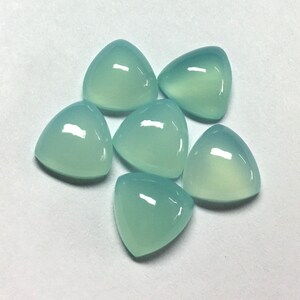 Puede incluir: Seis piedras preciosas triangulares en cabuj&oacute;n de color verde claro. Las piedras preciosas son lisas y pulidas.